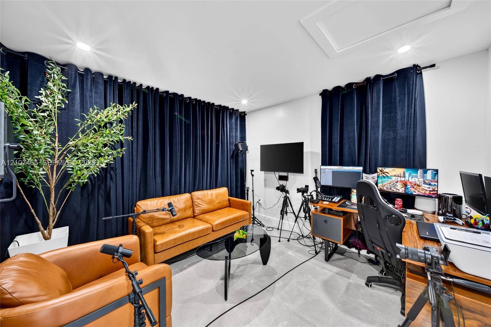 Neutral-toned interior space featuring recessed ceiling lighting, light grey flooring, and wall-mounted television bracket
