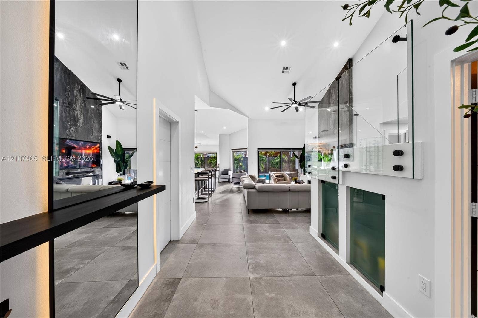 Vaulted ceilings, large-format tile flooring, integrated wall lighting, floor-to-ceiling mirrors, and architectural glass partitioning