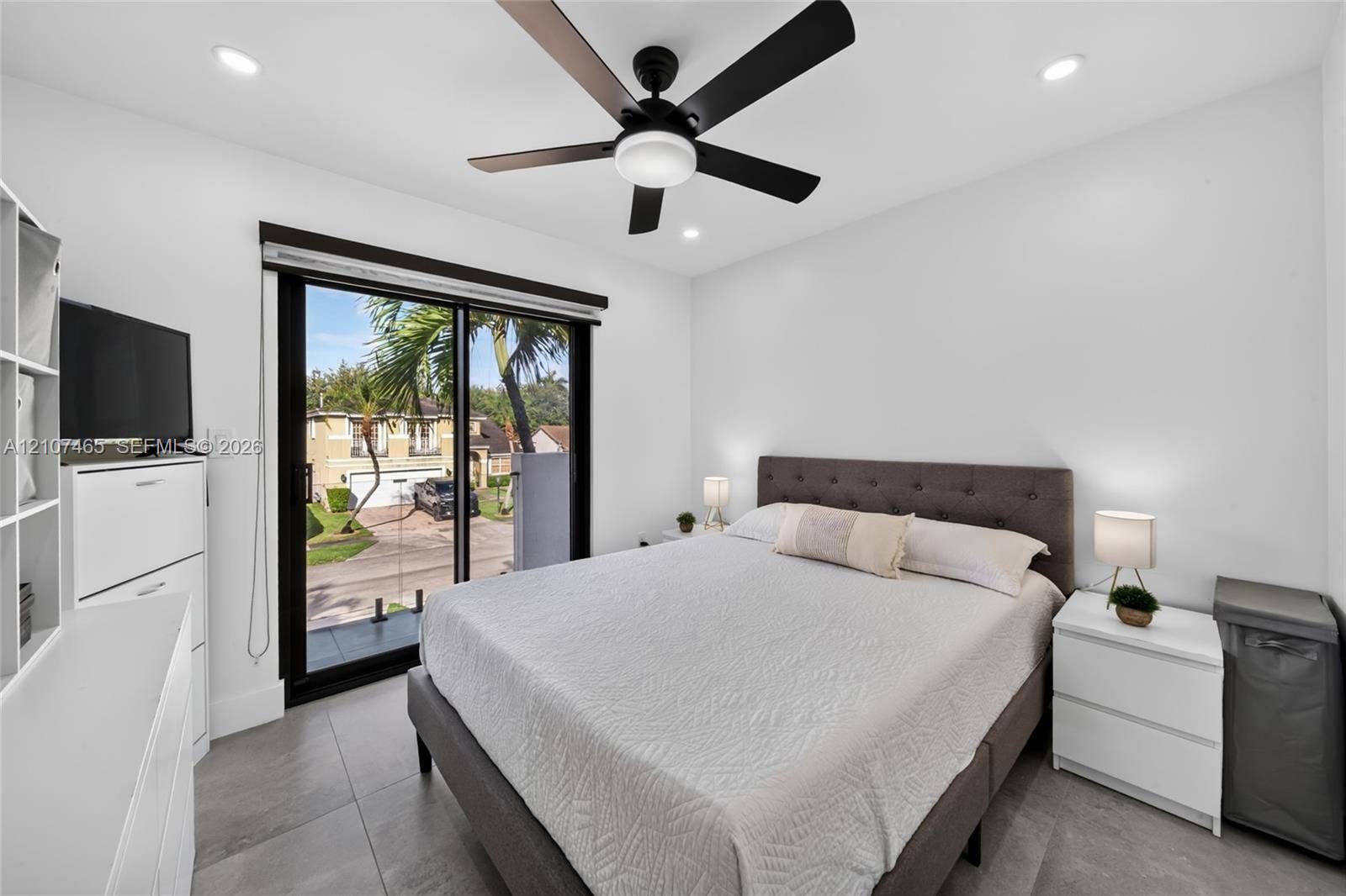 Neutral-toned ceramic tile flooring, ceiling fan with integrated lighting, recessed lighting, and black-framed glass sliding door