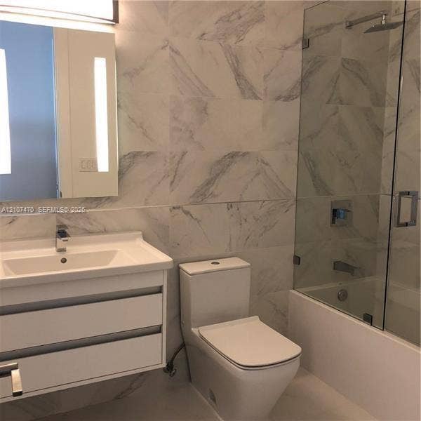 1629 NE 9th Street, #1629, Fort Lauderdale, Fort Lauderdale, FL 33304 Wall-mounted floating vanity with integrated rectangular sink, large-format veined tile wall surfacing, glass-enclosed shower, polished chrome fixtures, and integrated vanity lighting