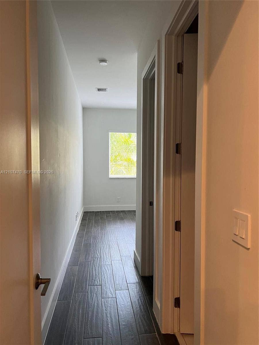 1629 NE 9th Street, #1629, Fort Lauderdale, Fort Lauderdale, FL 33304 Hallway featuring neutral-toned walls, wood-finish flooring, and a single window