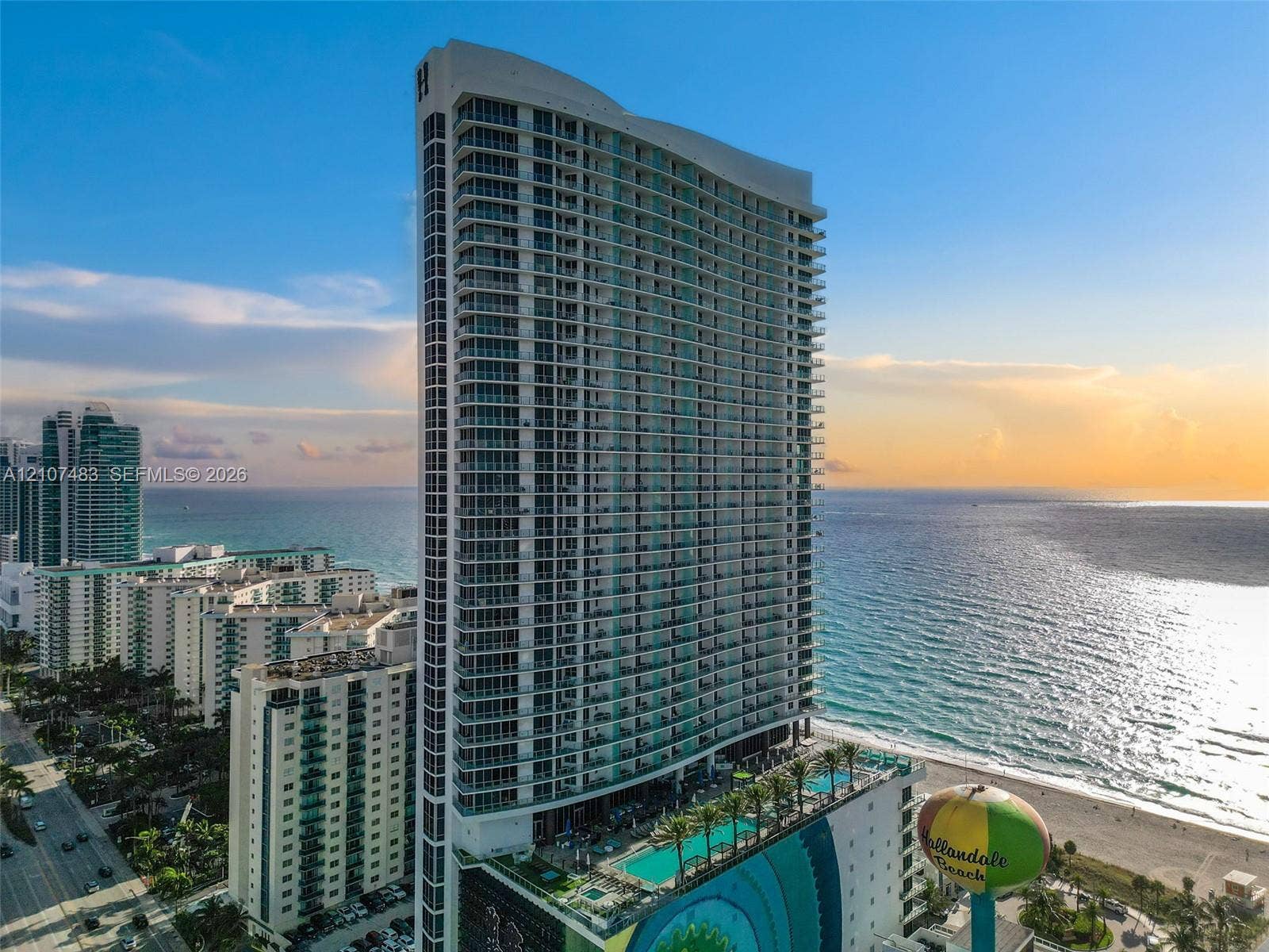 4111 S Ocean Drive, #2407, Hollywood, FL 33019 High-rise residential tower featuring a glass facade, multiple wrap-around balconies, and a multi-level podium deck with an outdoor swimming pool