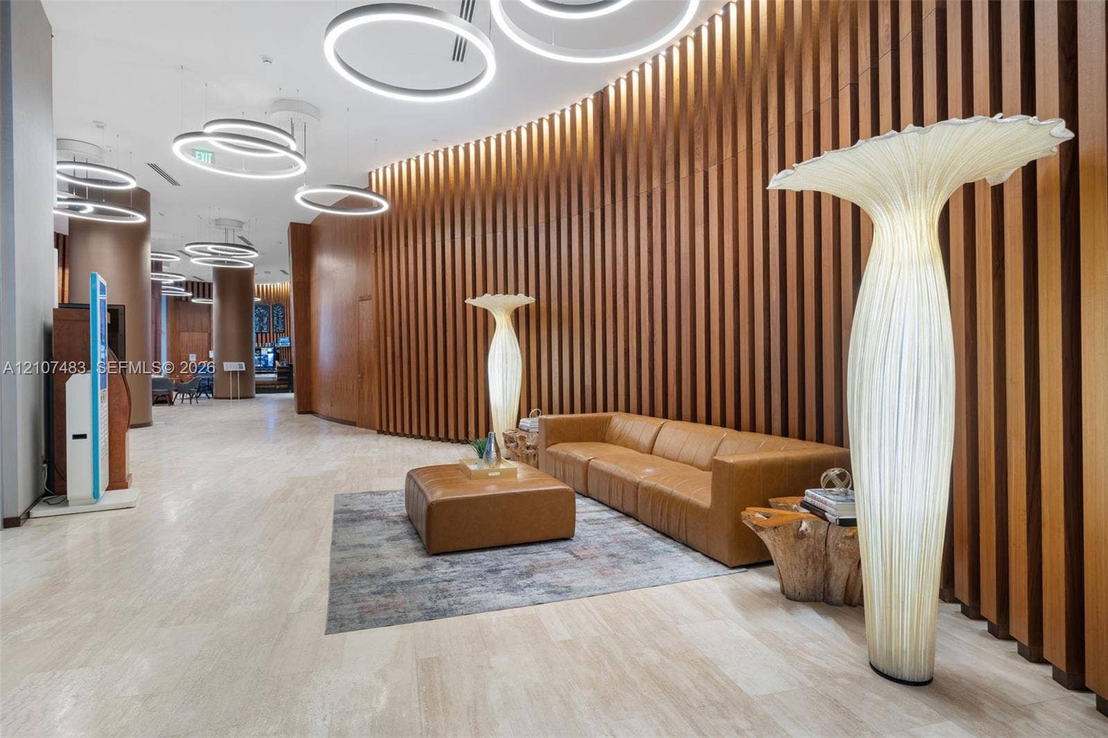 4111 S Ocean Drive, #2407, Hollywood, FL 33019 Curved wood-slat feature wall, polished stone flooring, and circular LED pendant lighting