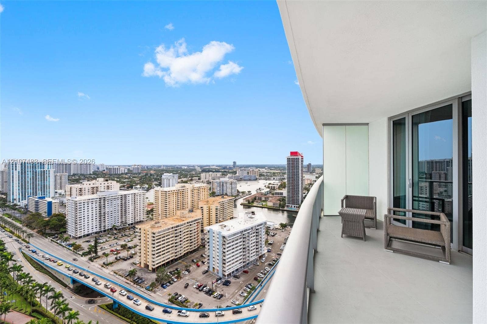 4111 S Ocean Drive, #2407, Hollywood, FL 33019 Private balcony with glass and metal railing, concrete flooring, and floor-to-ceiling glass entry doors