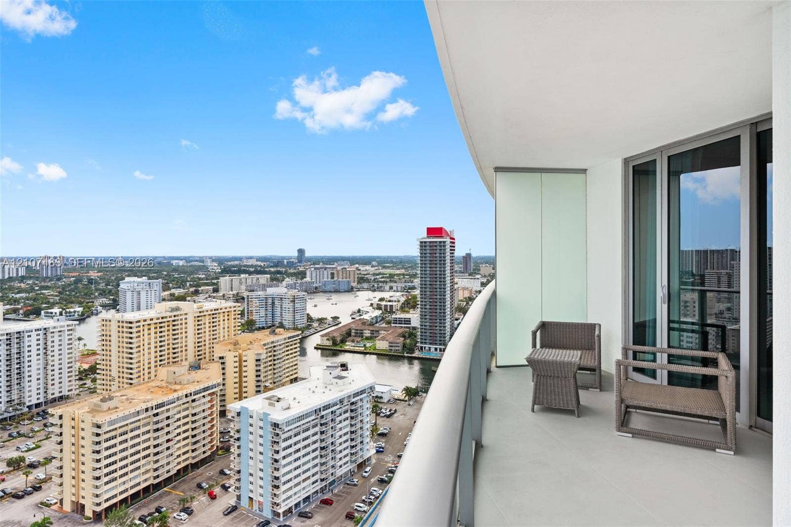 4111 S Ocean Drive, #2407, Hollywood, FL 33019 Covered balcony featuring glass panel railings and multi-panel sliding glass doors