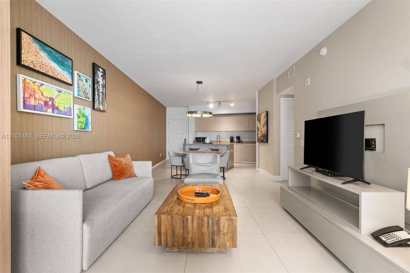 4111 S Ocean Drive, #2407, Hollywood, FL 33019 Open concept interior featuring large-format tile flooring, a textured accent wall, and recessed media wall shelving