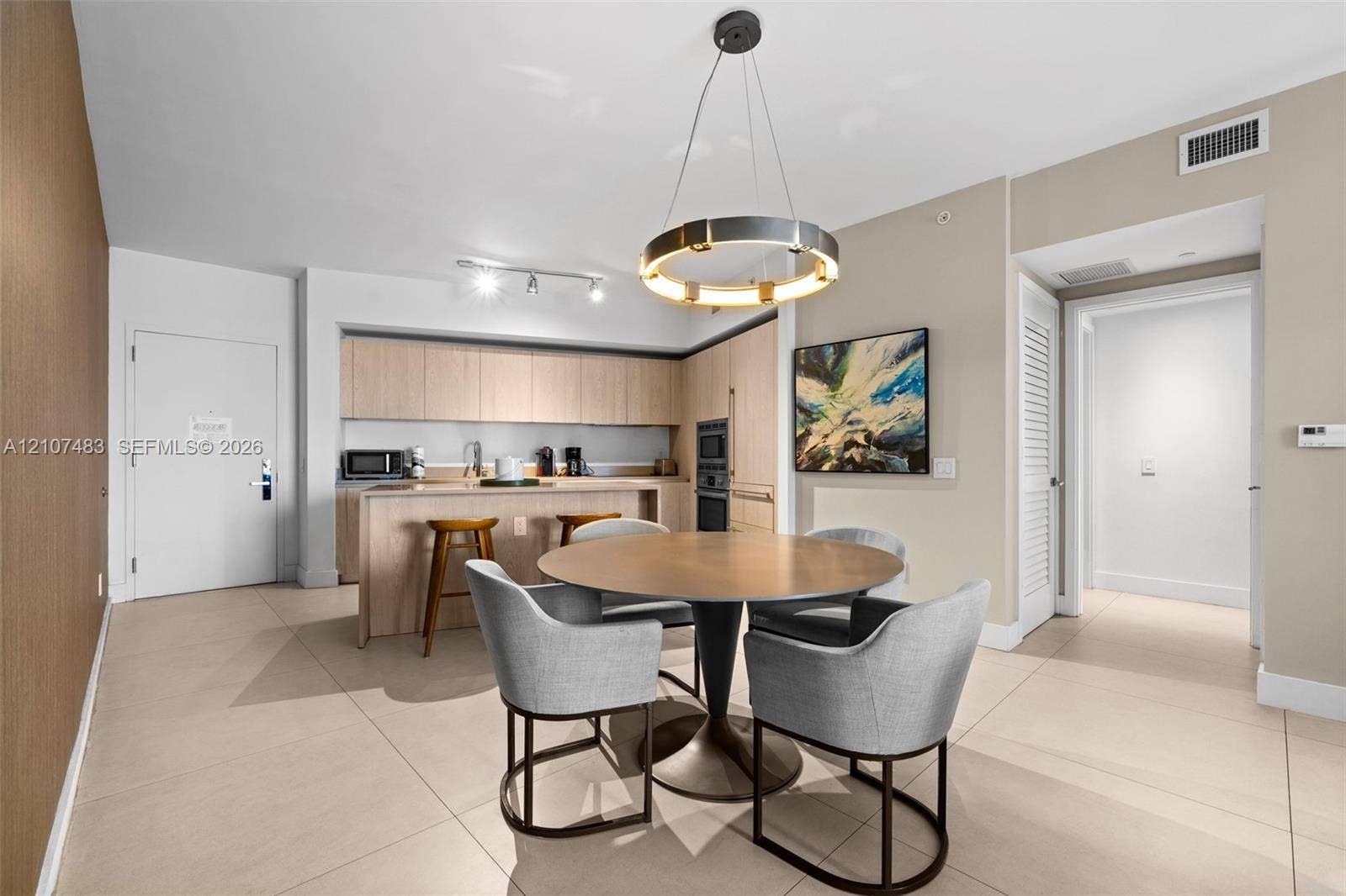 4111 S Ocean Drive, #2407, Hollywood, FL 33019 Kitchen featuring light-finish cabinetry, built-in wall oven, and a breakfast bar, complemented by a contemporary circular pendant light and tile flooring