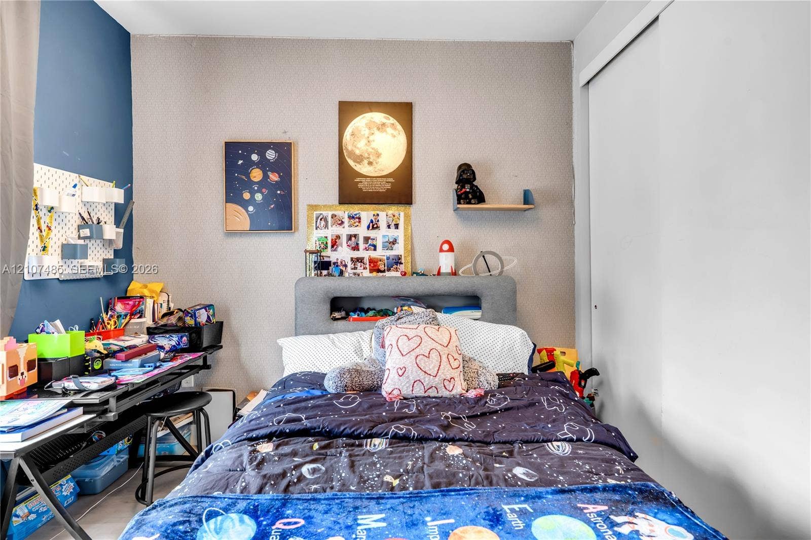 10545 NW 63rd Terrace, Doral, FL 33178 Bedroom featuring an accent wall, closet with sliding doors, and neutral wall tones