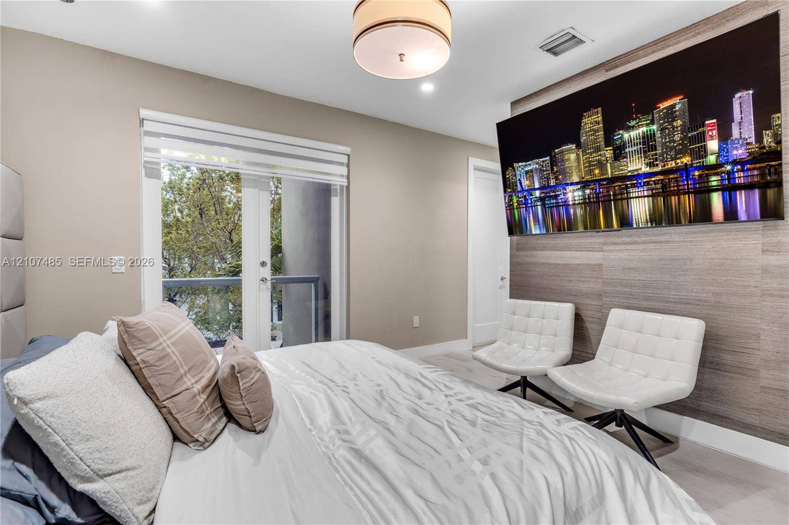 10545 NW 63rd Terrace, Doral, FL 33178 Room featuring horizontal wood-paneled accent wall, glass-paned French doors with integrated blinds, and modern drum-style ceiling light fixture