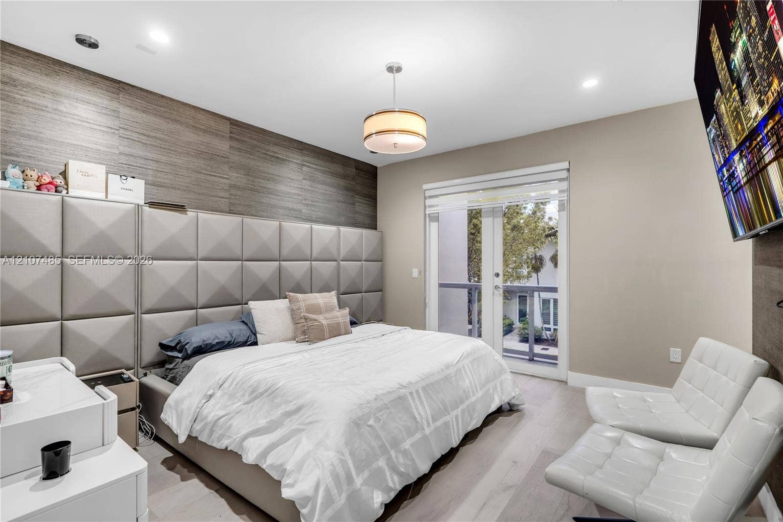 10545 NW 63rd Terrace, Doral, FL 33178 Custom upholstered wall paneling, wood-finish flooring, recessed lighting, central pendant fixture, and glass-paneled exterior door