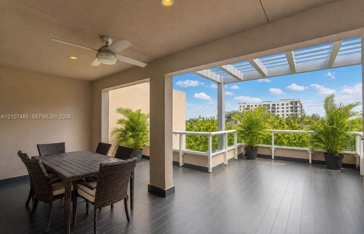 10545 NW 63rd Terrace, Doral, FL 33178 Covered terrace featuring dark plank flooring, a built-in ceiling fan, recessed lighting, and a pergola-style overhead structure with white railing
