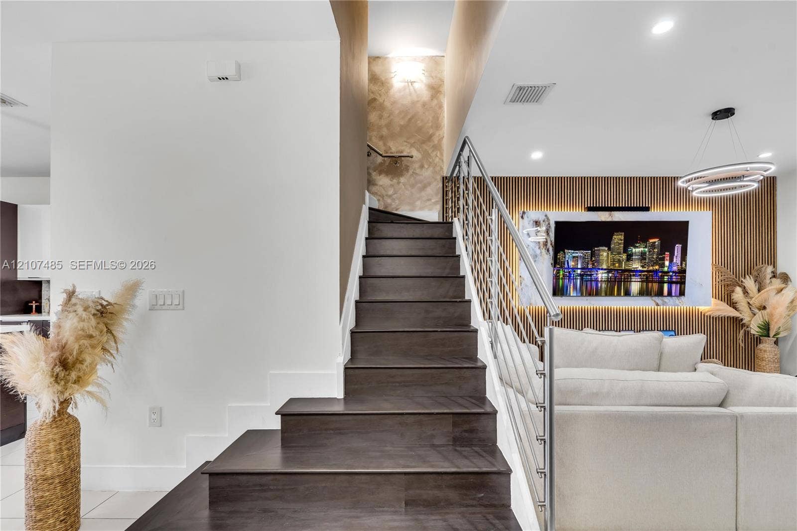 10545 NW 63rd Terrace, Doral, FL 33178 Staircase featuring dark wood-finish treads, a custom cable railing system, vertical slat wall paneling, and recessed lighting