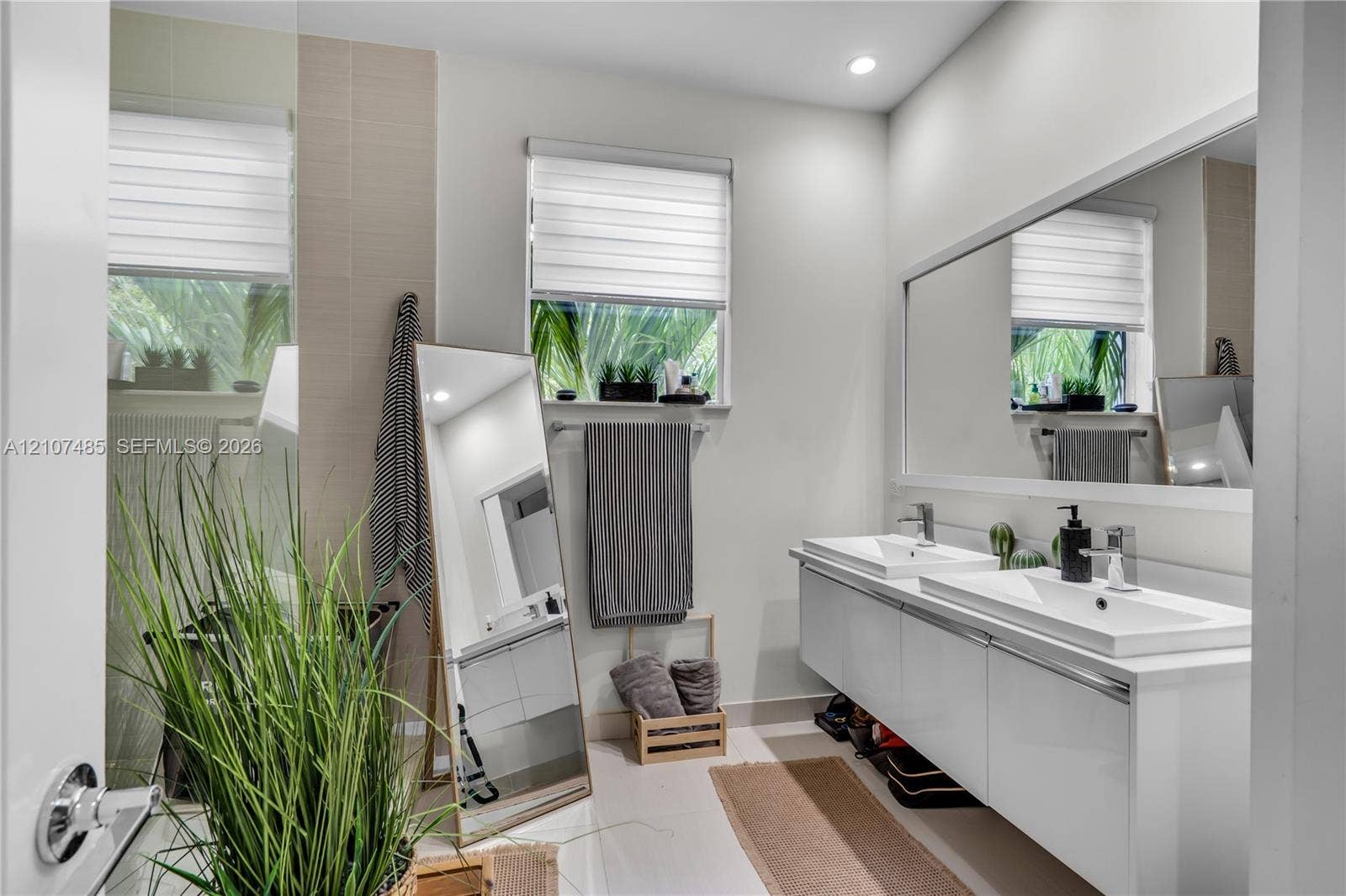 10545 NW 63rd Terrace, Doral, FL 33178 Floating double vanity featuring rectangular integrated sinks, chrome hardware, recessed lighting, and a full-width wall mirror