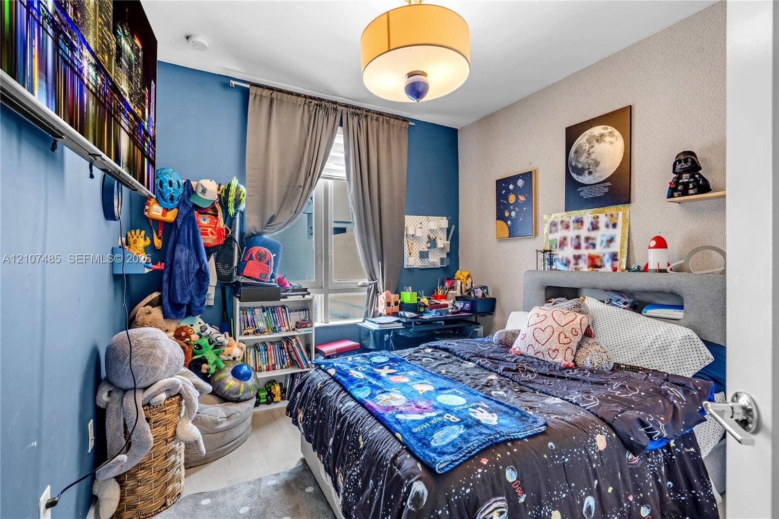 10545 NW 63rd Terrace, Doral, FL 33178 Room featuring light-toned flooring, a drum-style pendant light fixture, and a window with neutral-toned drapery