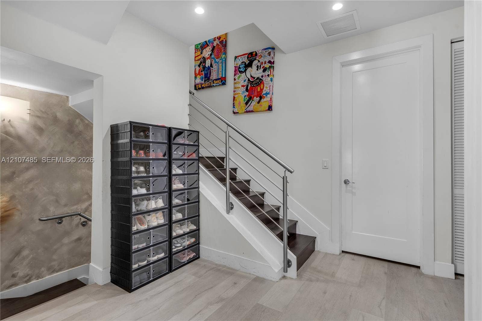10545 NW 63rd Terrace, Doral, FL 33178 Staircase featuring dark wood treads, white risers, and a stainless steel horizontal cable railing system, complemented by wood-finish flooring and recessed ceiling lighting