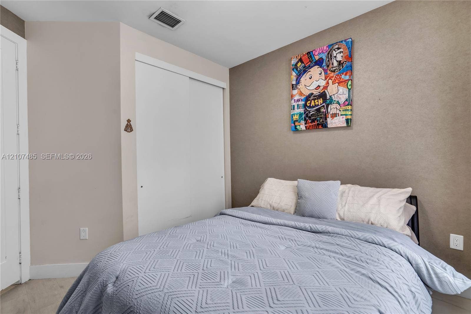 10545 NW 63rd Terrace, Doral, FL 33178 Room featuring neutral wall paint, a designated accent wall, and a built-in closet with white sliding doors
