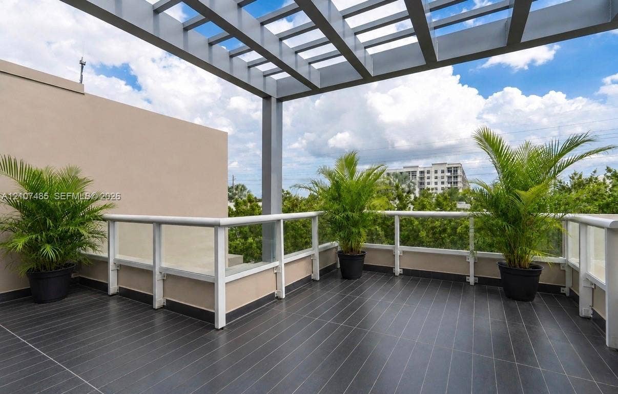 10545 NW 63rd Terrace, Doral, FL 33178 Terrace featuring dark tile flooring, a metal pergola, and glass panel railing