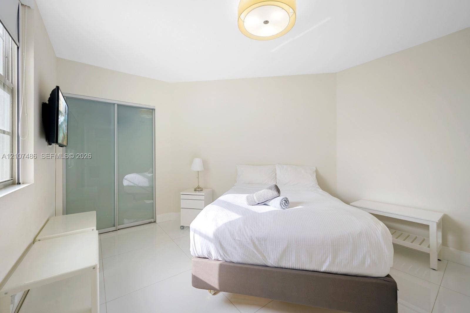 19370 Collins Avenue, #916, Sunny Isles Beach, Sunny Isles Beach, FL 33160 Bright room featuring large-format tile flooring, sliding glass-panel closet doors, and a neutral color palette
