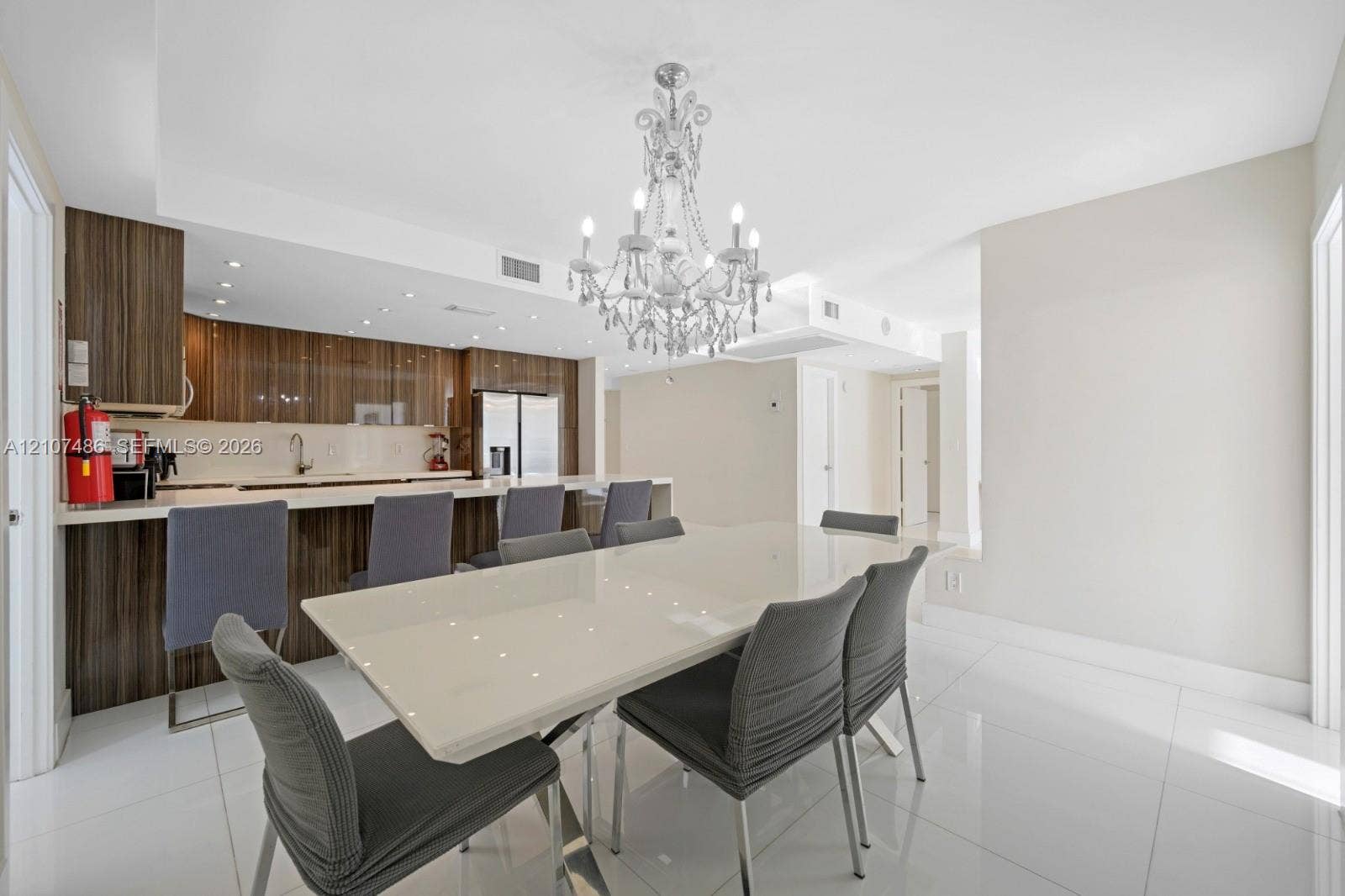 19370 Collins Avenue, #916, Sunny Isles Beach, Sunny Isles Beach, FL 33160 Kitchen featuring horizontal-grain wood cabinetry, integrated stainless steel appliances, and a breakfast bar with stone-surfaced countertops