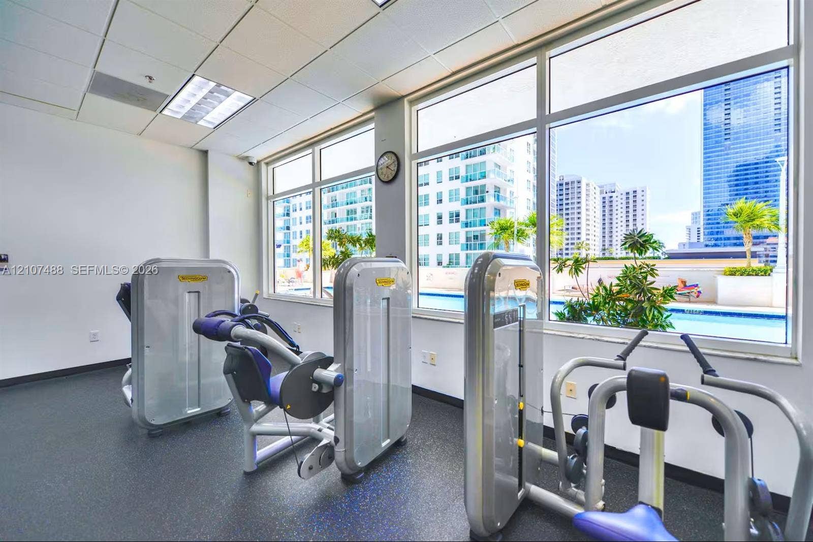 Fitness center featuring rubber flooring, oversized windows, and built-in exercise machines