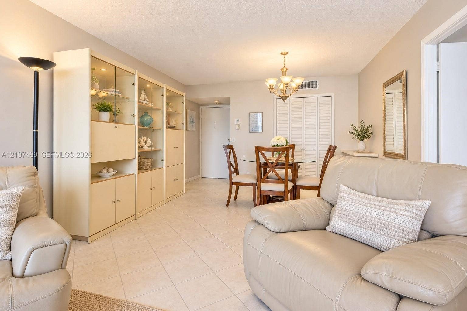 2000 S Ocean Boulevard, #9N, Lauderdale-By-The-Sea, Lauderdale By The Sea, FL 33062 Interior space featuring diagonal tile flooring, custom built-in cabinetry with glass-front display sections, and a multi-arm chandelier