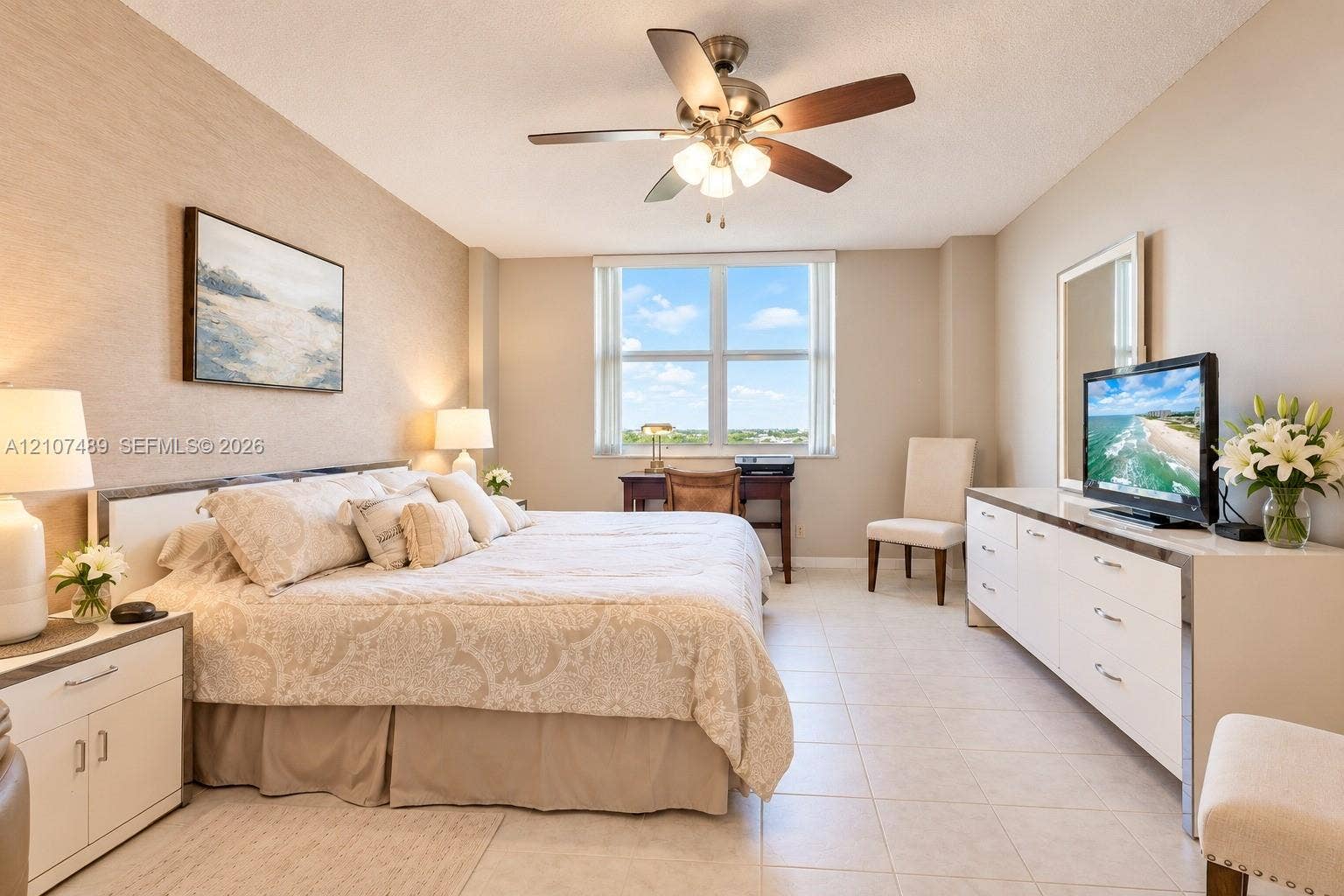 2000 S Ocean Boulevard, #9N, Lauderdale-By-The-Sea, Lauderdale By The Sea, FL 33062 Neutral-toned interior space featuring large windows, textured wall surfacing, neutral tile flooring, and a multi-blade ceiling fan with integrated lighting