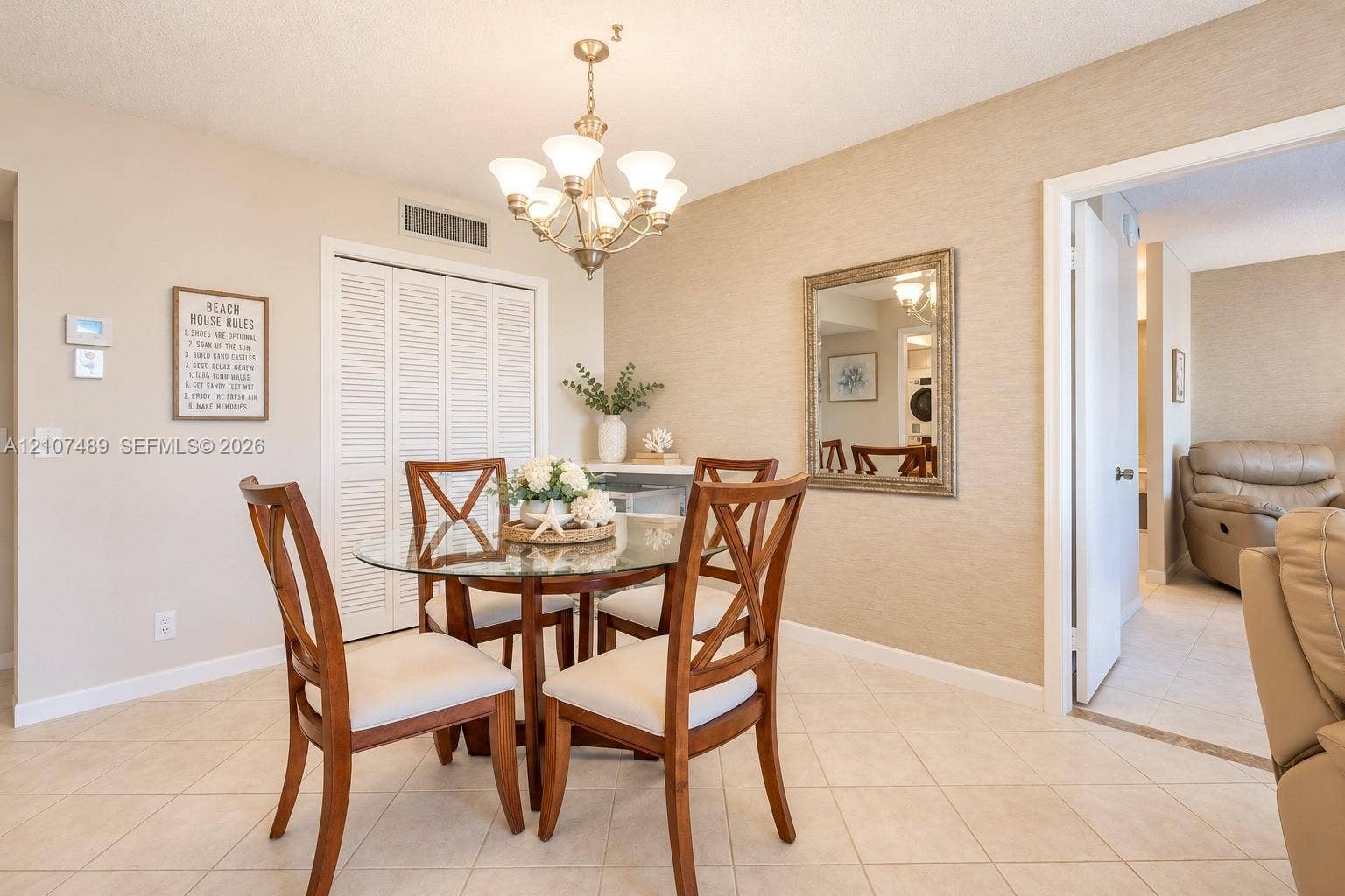 2000 S Ocean Boulevard, #9N, Lauderdale-By-The-Sea, Lauderdale By The Sea, FL 33062 Dining area featuring textured wall finish, ceramic tile flooring, a multi-light metal chandelier, and a louvered-door storage closet