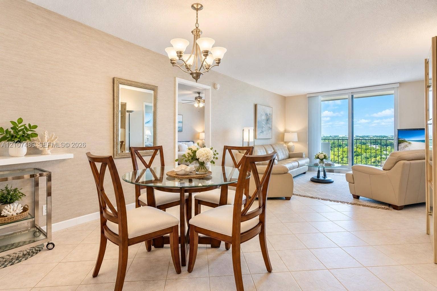 2000 S Ocean Boulevard, #9N, Lauderdale-By-The-Sea, Lauderdale By The Sea, FL 33062 Open-concept space featuring neutral textured wall treatments, large-format tile flooring, a multi-arm chandelier, and floor-to-ceiling glass sliding doors
