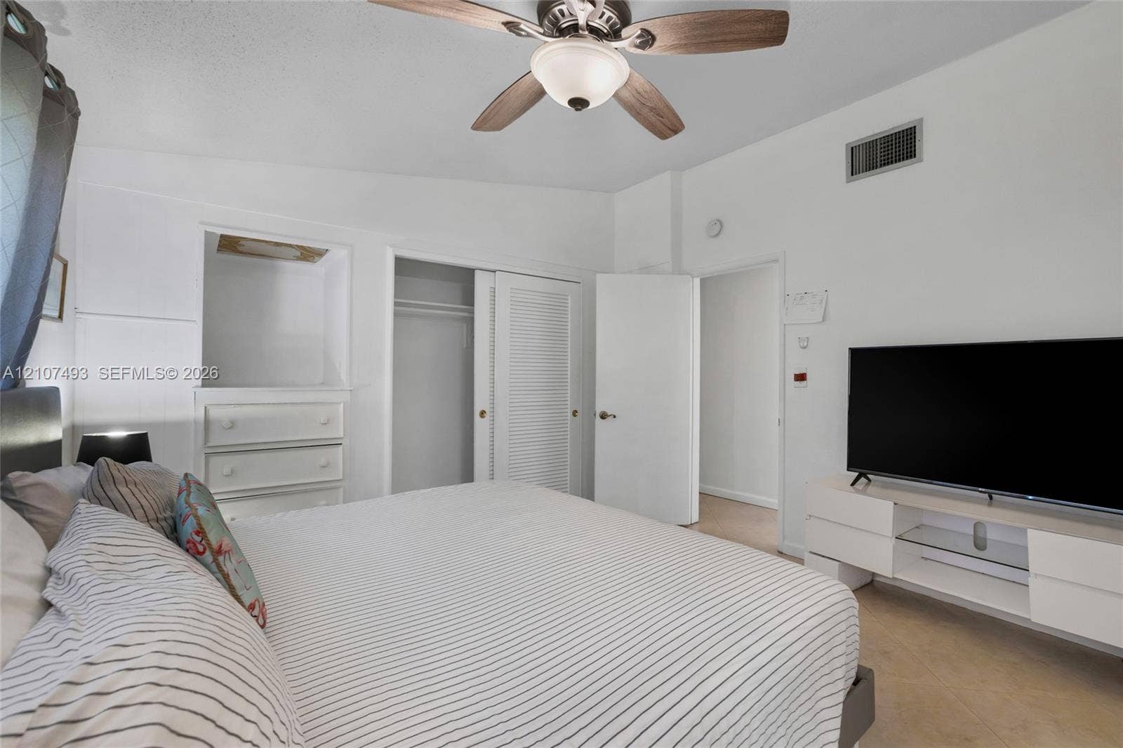 2645 NE 32nd Street, Fort Lauderdale, FL 33306 Vaulted ceilings, ceiling fan with light fixture, built-in cabinetry, and closet with louvered doors