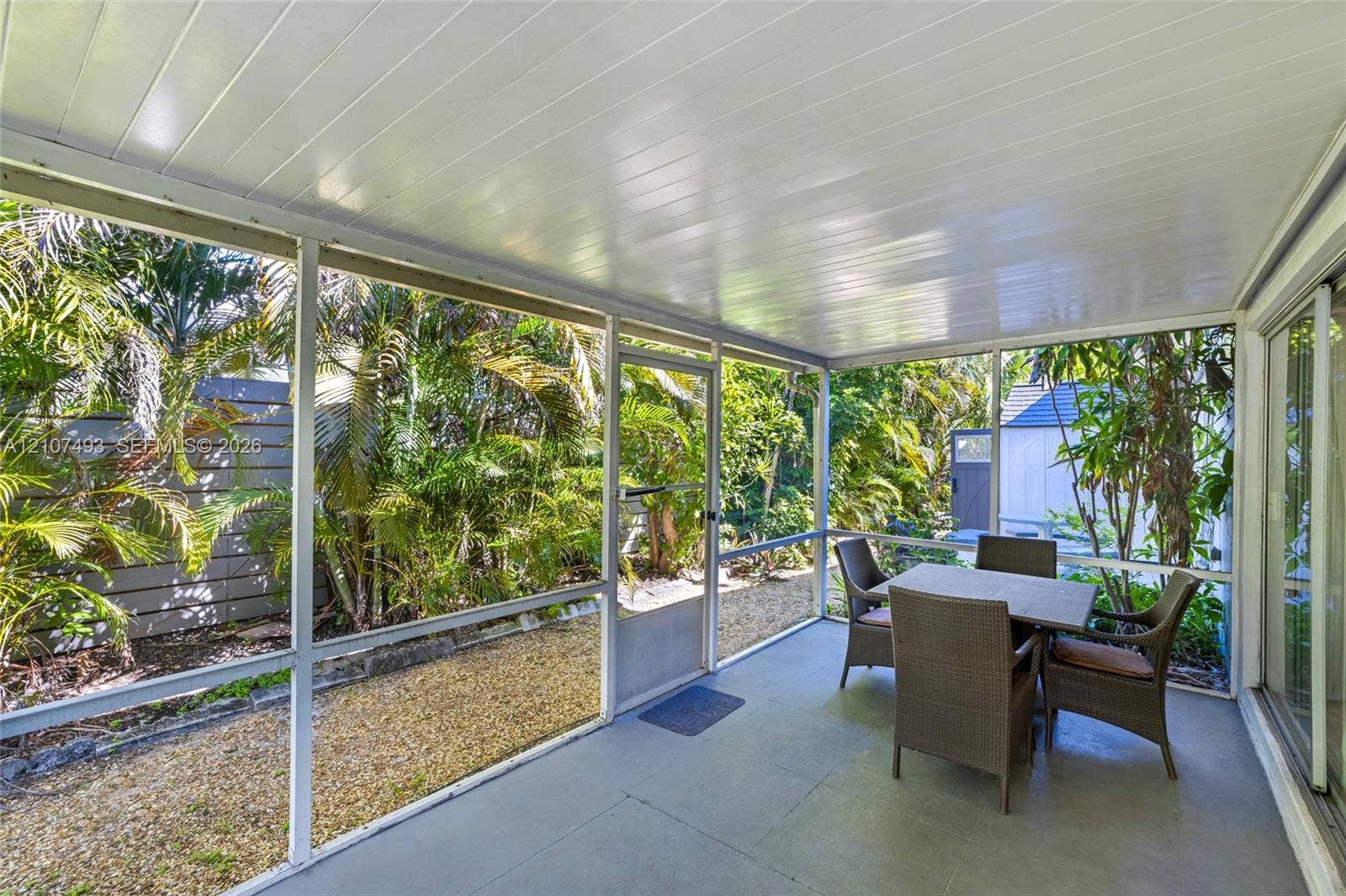 2645 NE 32nd Street, Fort Lauderdale, FL 33306 Screened-in porch featuring a painted concrete floor, a beadboard ceiling, and full-height mesh screening
