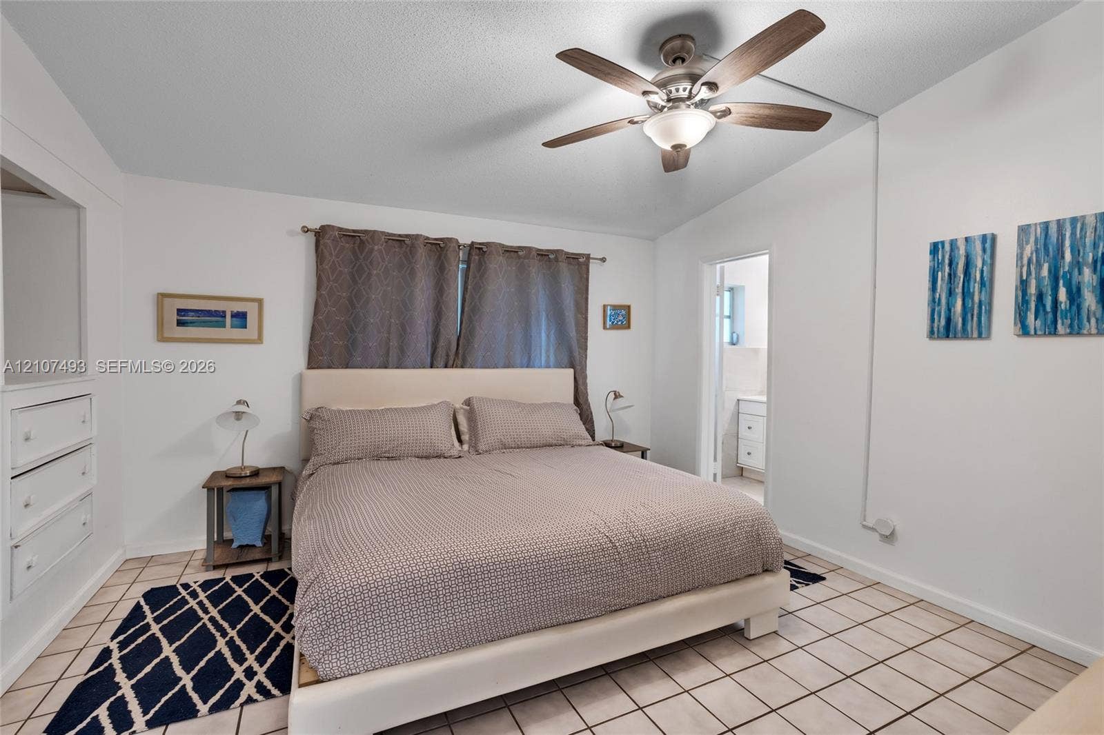 2645 NE 32nd Street, Fort Lauderdale, FL 33306 Bedroom featuring tile flooring, ceiling fan with integrated lighting, and built-in cabinetry