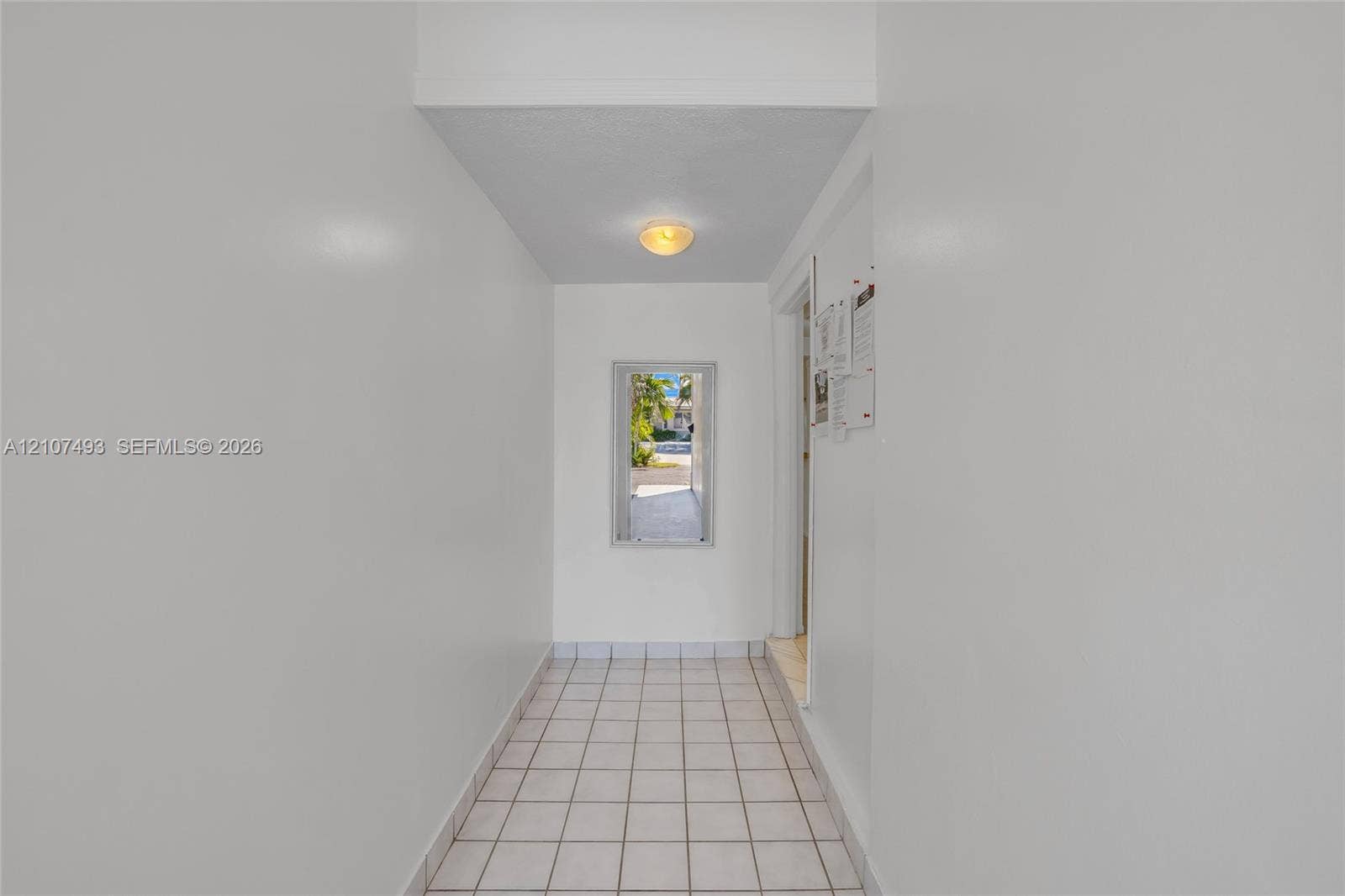 2645 NE 32nd Street, Fort Lauderdale, FL 33306 Interior hall featuring white tile flooring, neutral wall finishes, and a flush-mount light fixture