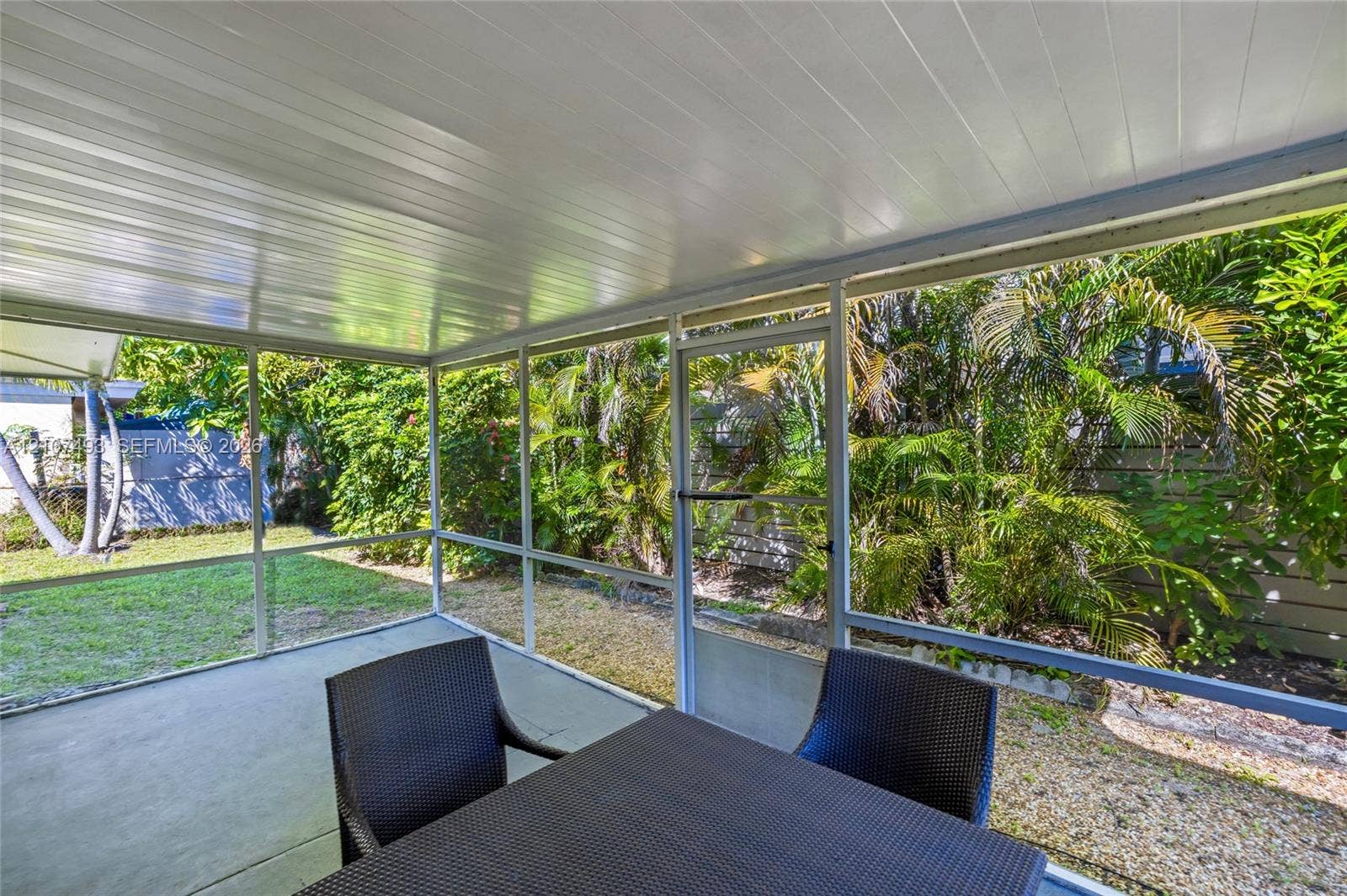 2645 NE 32nd Street, Fort Lauderdale, FL 33306 Screened-in patio featuring a concrete floor, white tongue-and-groove ceiling, and a full-height screen enclosure