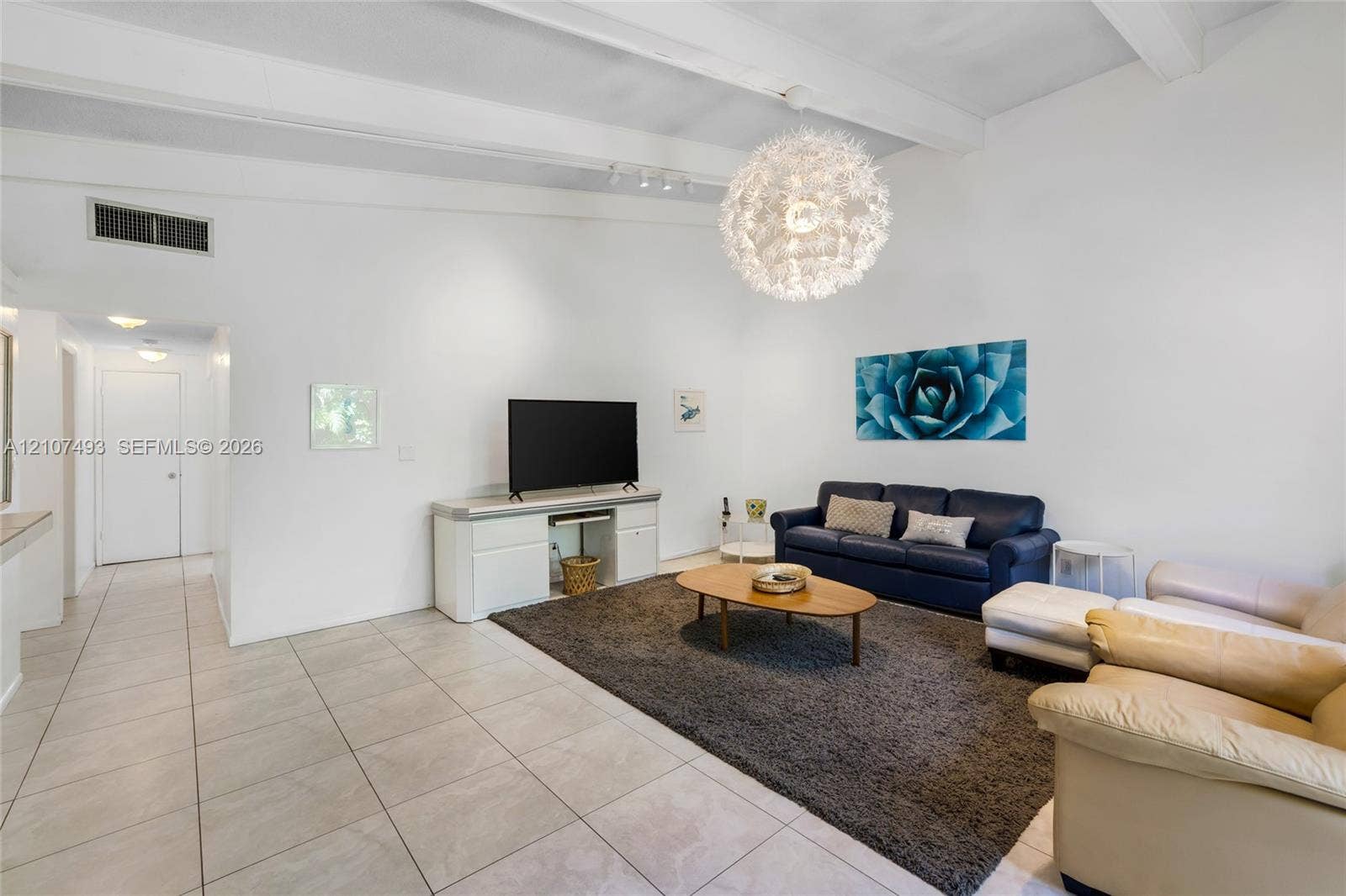 2645 NE 32nd Street, Fort Lauderdale, FL 33306 Vaulted ceilings with exposed beams, large spherical chandelier, and ceramic tile flooring