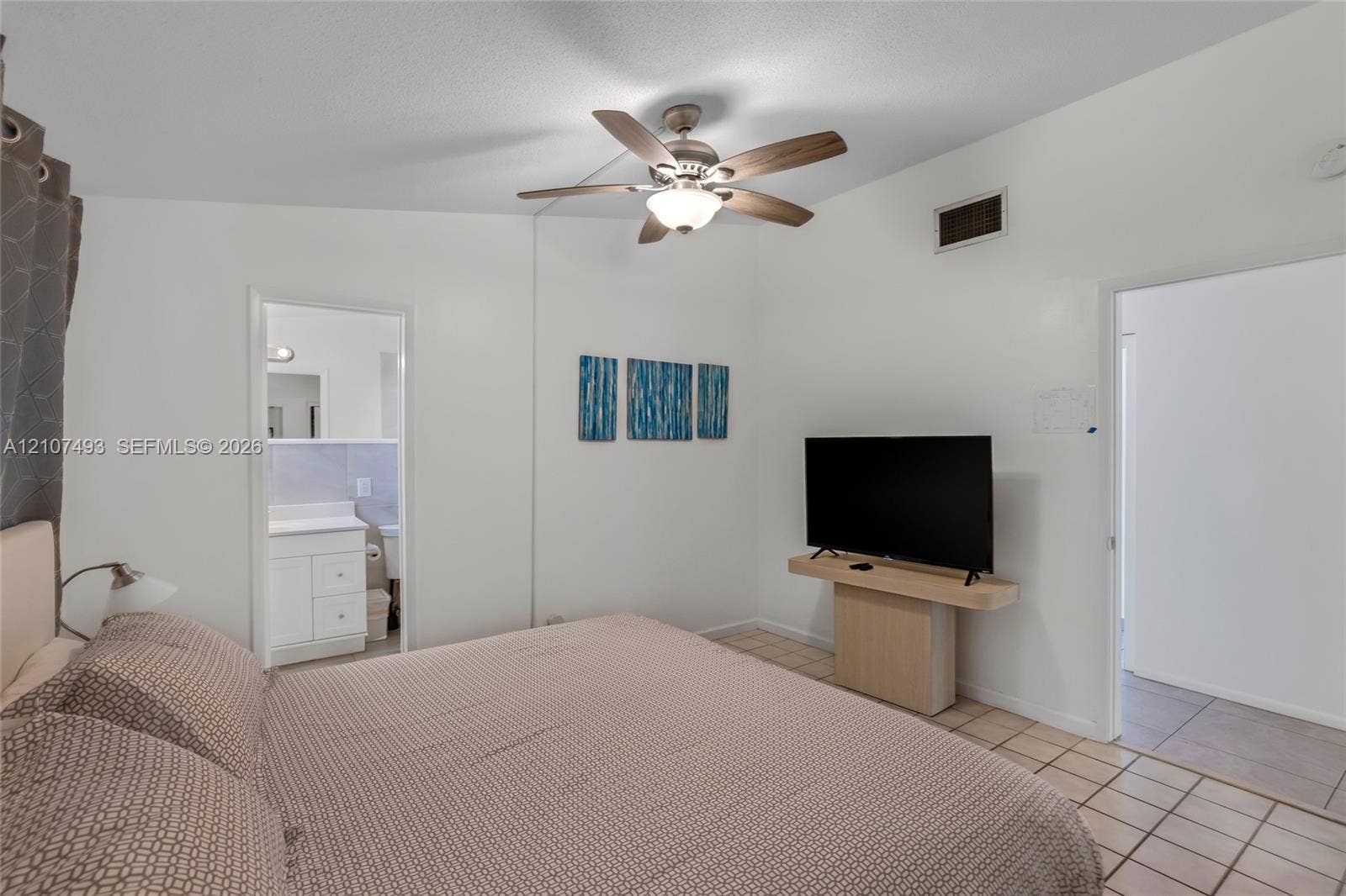 2645 NE 32nd Street, Fort Lauderdale, FL 33306 Vaulted ceiling featuring a central multi-blade ceiling fan with integrated light fixture and large-format tile flooring