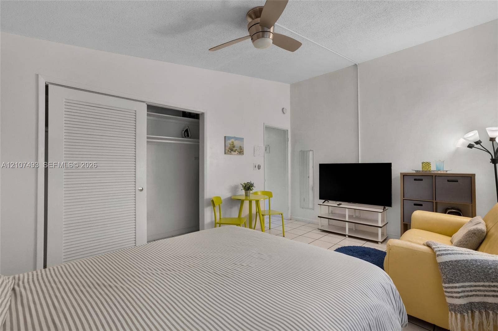 2645 NE 32nd Street, Fort Lauderdale, FL 33306 Room featuring neutral-toned walls, tile flooring, a ceiling fan with integrated lighting, and a closet with louvered doors
