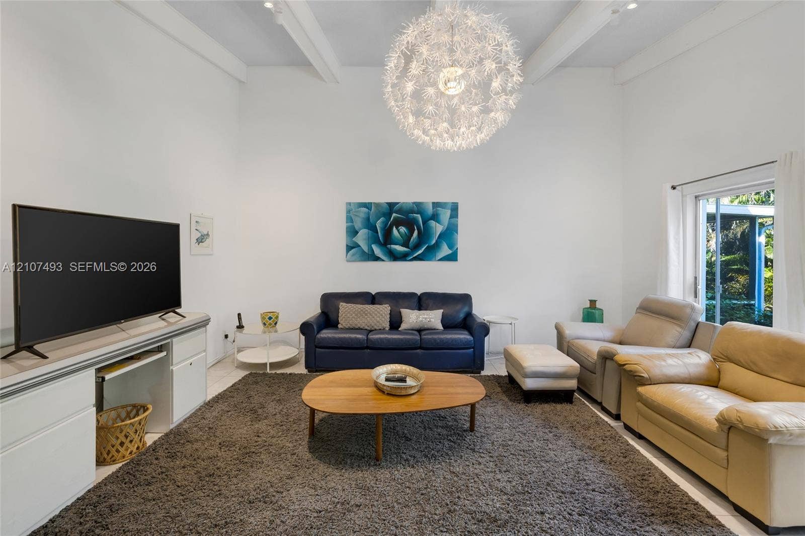 2645 NE 32nd Street, Fort Lauderdale, FL 33306 High vaulted ceilings featuring exposed structural beams, a statement spherical pendant light fixture, and floor-to-ceiling glass sliding doors