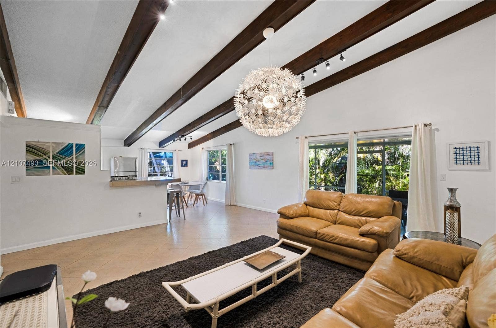 2645 NE 32nd Street, Fort Lauderdale, FL 33306 Vaulted ceiling with exposed wood beams, tile flooring, large-scale pendant lighting, and oversized windows