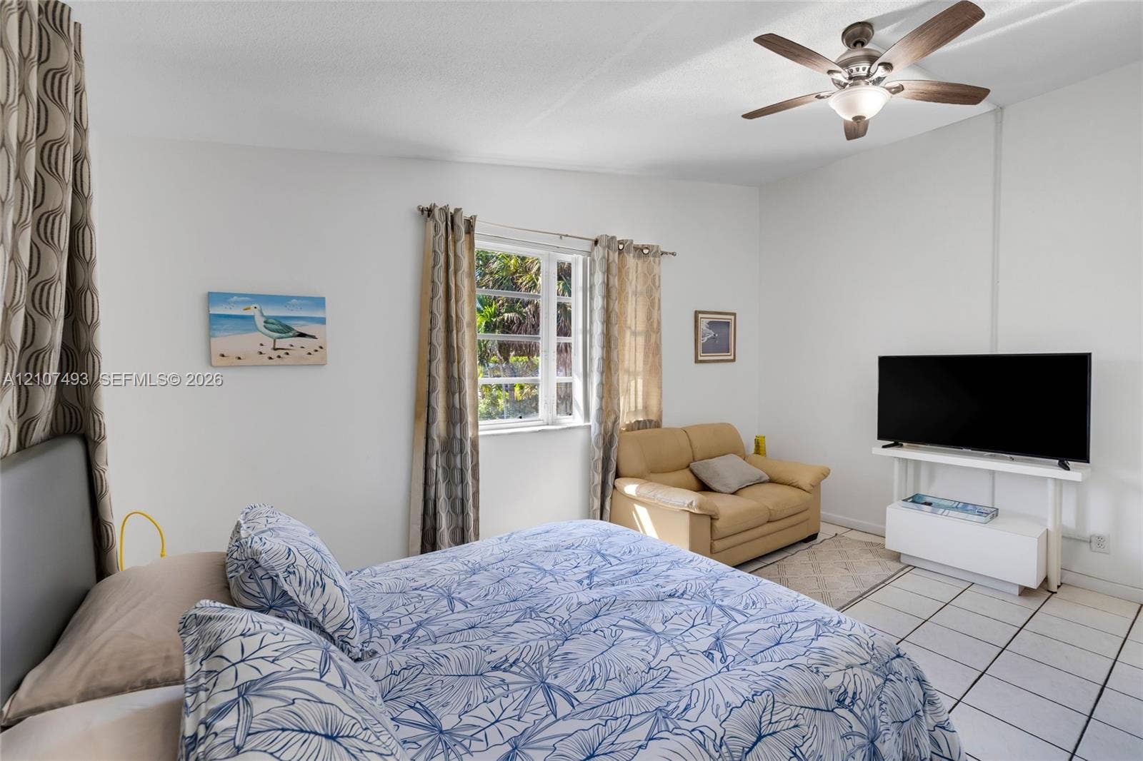 2645 NE 32nd Street, Fort Lauderdale, FL 33306 Room featuring ceramic tile flooring, multi-pane window, and ceiling fan with integrated light fixture