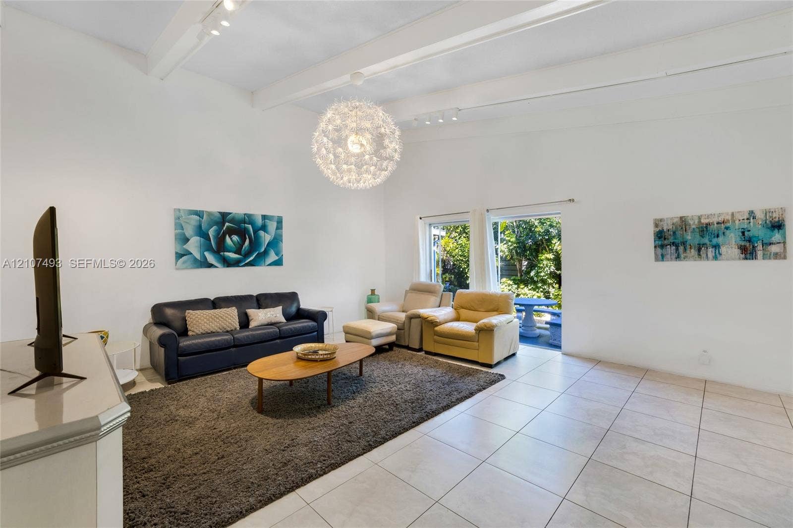 2645 NE 32nd Street, Fort Lauderdale, FL 33306 Vaulted ceilings with exposed structural beams, tile flooring, and a large spherical pendant light fixture