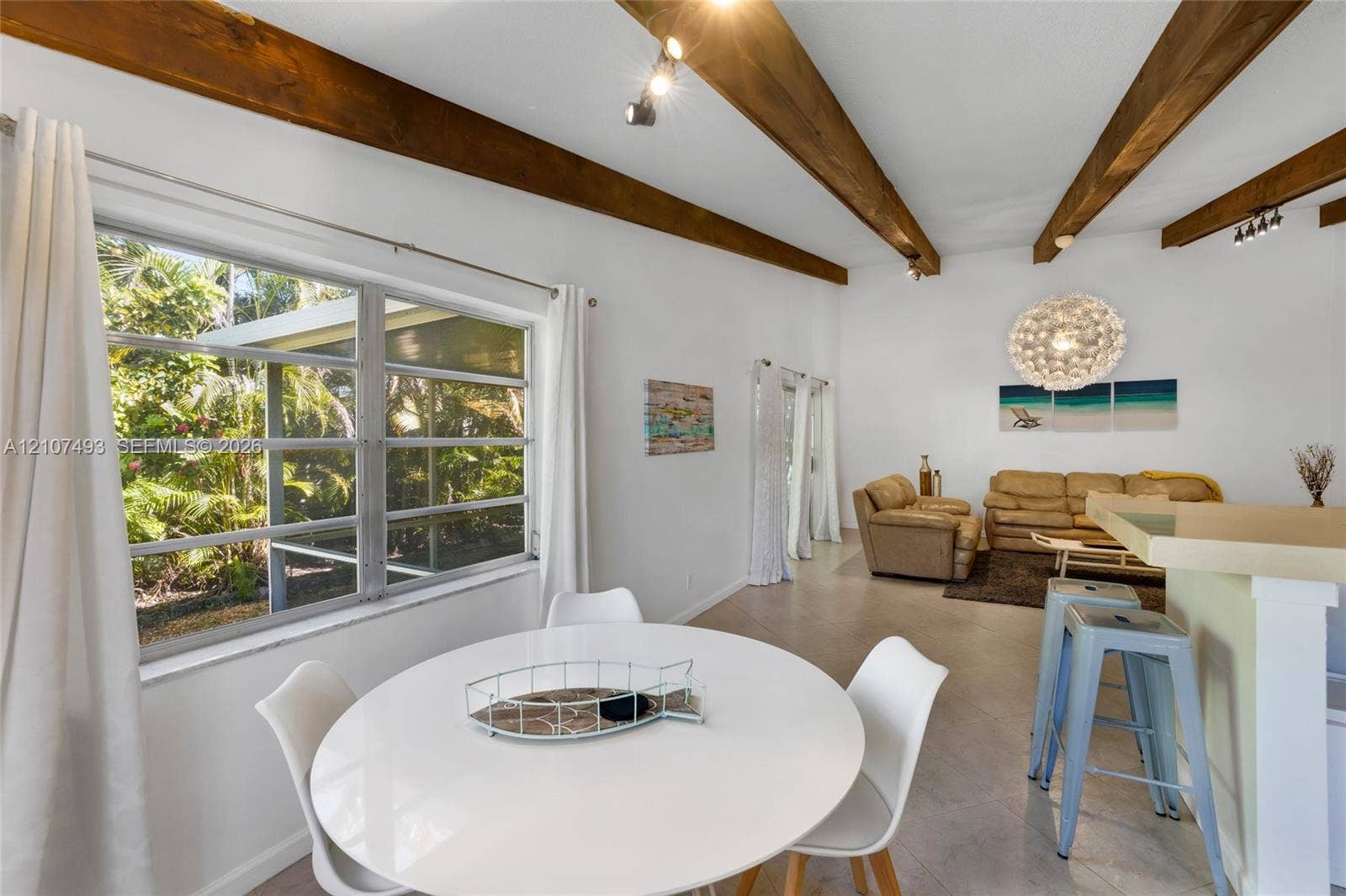 2645 NE 32nd Street, Fort Lauderdale, FL 33306 Vaulted ceiling with exposed wood beams, neutral floor tile, and large picture windows