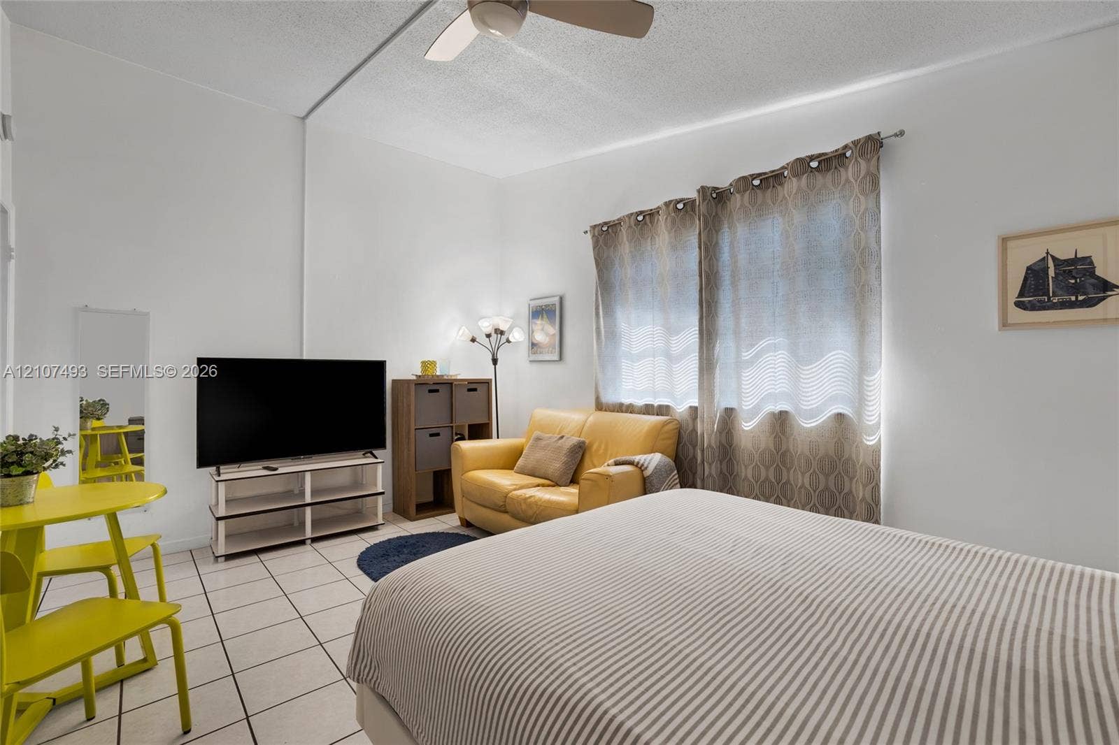2645 NE 32nd Street, Fort Lauderdale, FL 33306 Interior space featuring white walls, light-toned ceramic tile flooring, and a ceiling-mounted light fixture with integrated fan