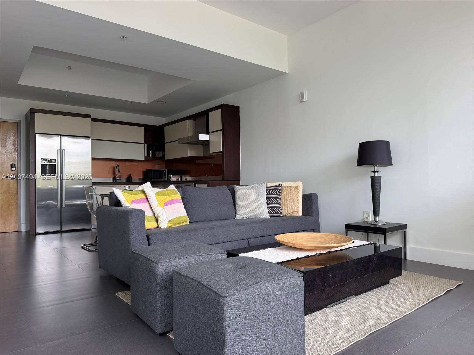 2100 Park Avenue, #305, Miami Beach, Miami Beach, FL 33139 Open-concept area featuring oversized neutral floor tiling, recessed ceiling detail, and kitchen cabinetry with a two-tone finish