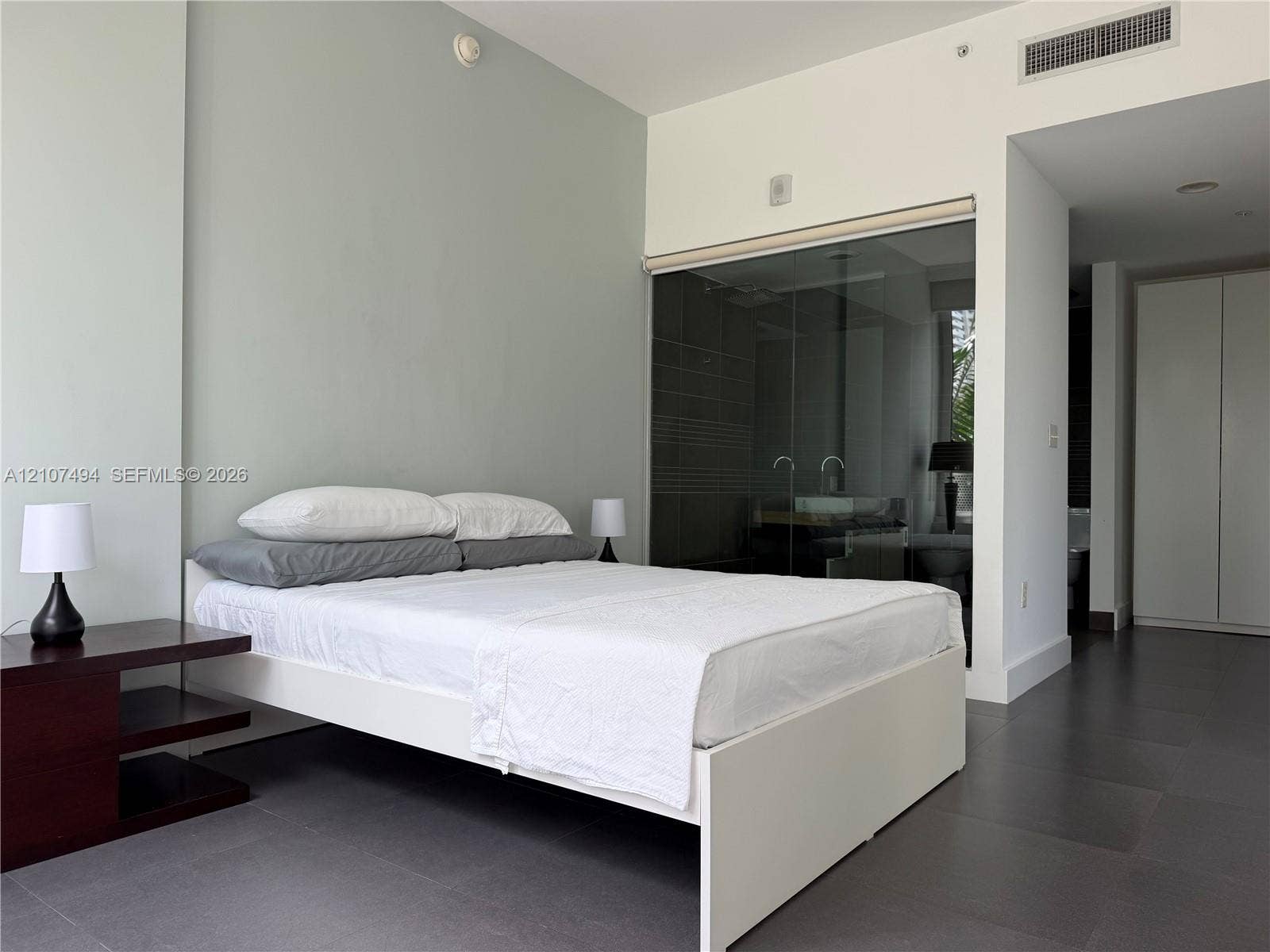 2100 Park Avenue, #305, Miami Beach, Miami Beach, FL 33139 Interior room featuring large-format dark floor tiling, neutral wall finish, floor-to-ceiling glass wall enclosure, and integrated cabinetry