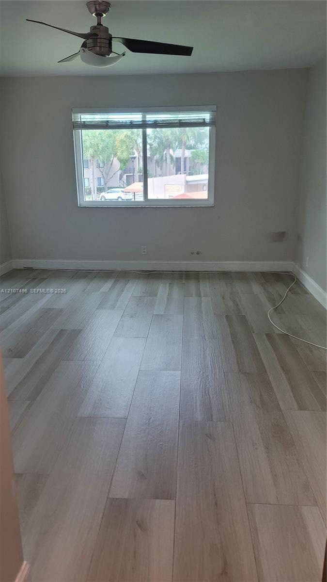 330 Racquet Club Road, #204, Weston, Weston, FL 33326 Interior space featuring wood-finish flooring, neutral wall paint, and a ceiling fan with integrated lighting
