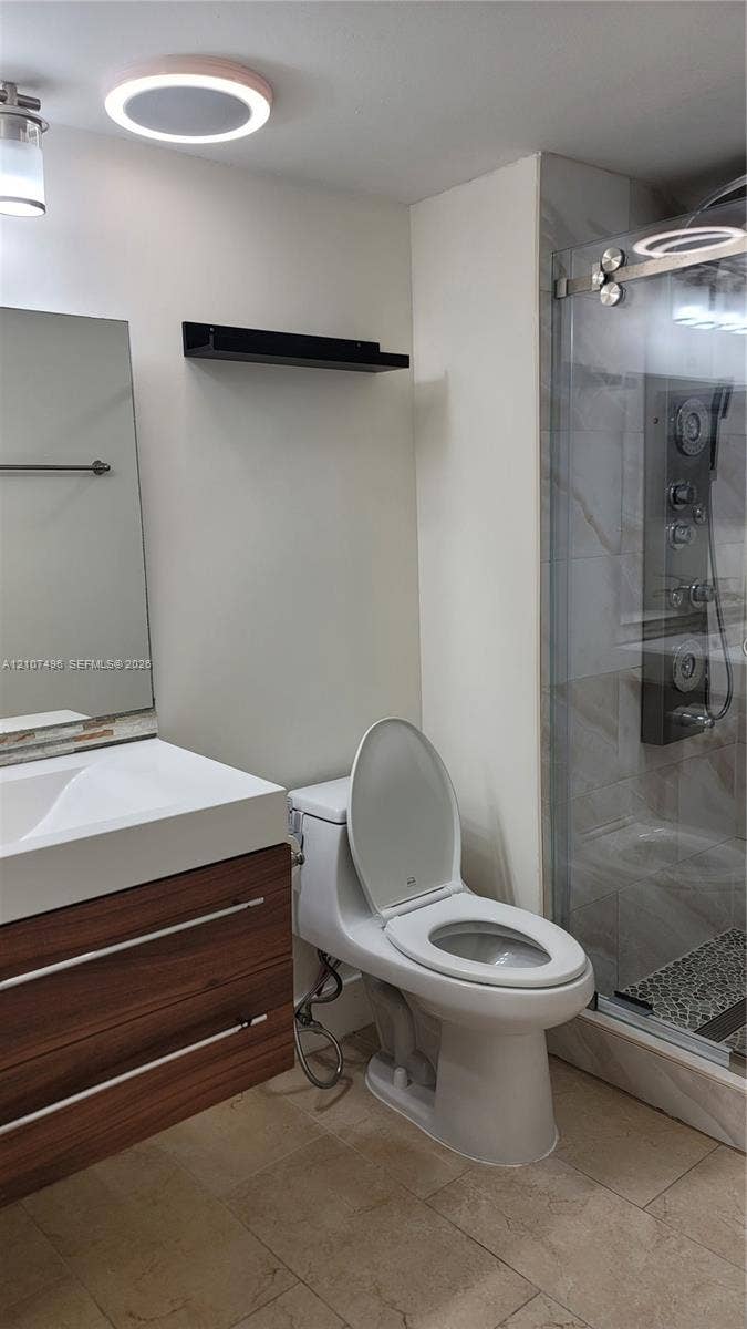 330 Racquet Club Road, #204, Weston, Weston, FL 33326 Modern floating vanity with a wood-finish cabinet and integrated sink, glass-enclosed shower featuring a multi-jet panel system, and light-toned floor tiling