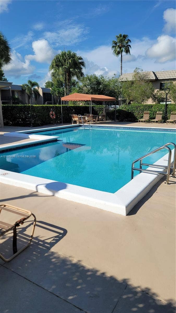 330 Racquet Club Road, #204, Weston, Weston, FL 33326 Swimming pool with a concrete deck, built-in metal handrails, and a covered patio area