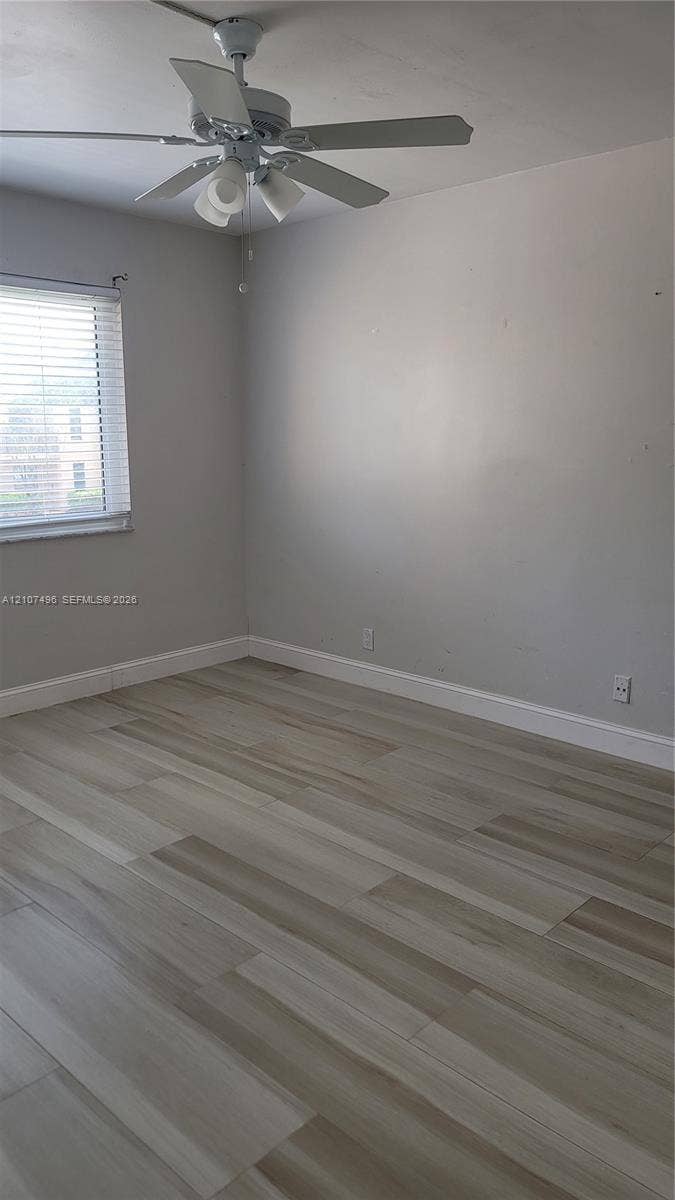 330 Racquet Club Road, #204, Weston, Weston, FL 33326 Interior space featuring wood-finish flooring, neutral wall paint, and a ceiling-mounted light fixture with a fan