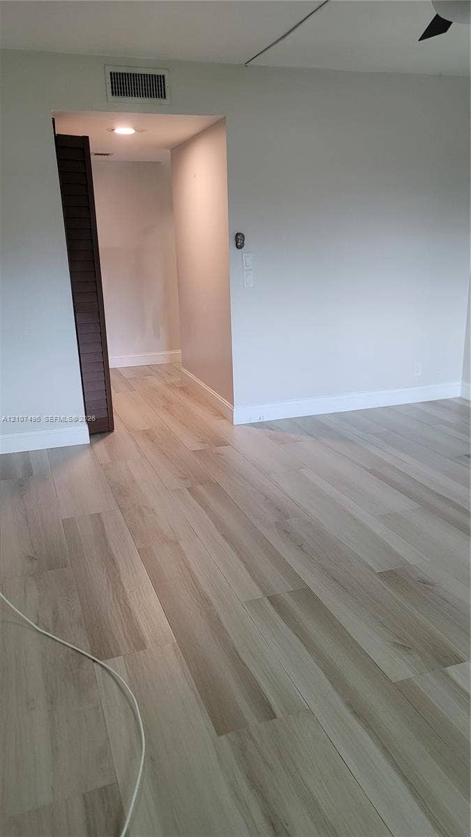 330 Racquet Club Road, #204, Weston, Weston, FL 33326 Light-toned wood-finish flooring, neutral wall palette, and louvered closet door featuring recessed ceiling lighting