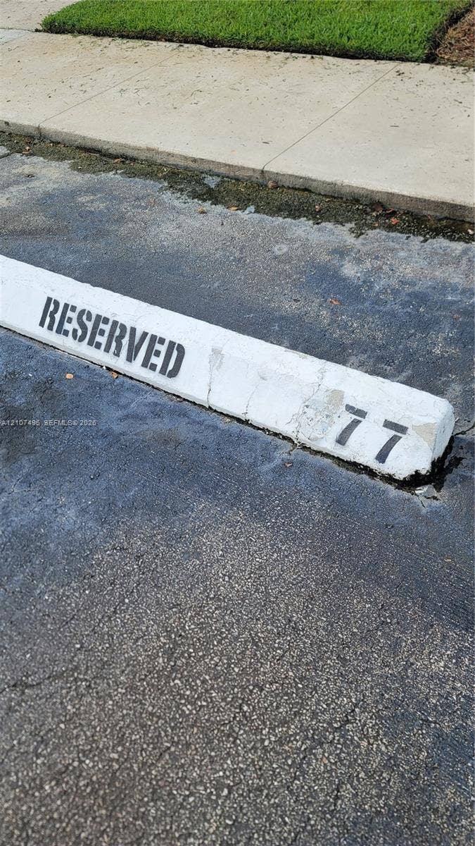 330 Racquet Club Road, #204, Weston, Weston, FL 33326 Designated parking space 77 featuring asphalt paving and concrete curbing